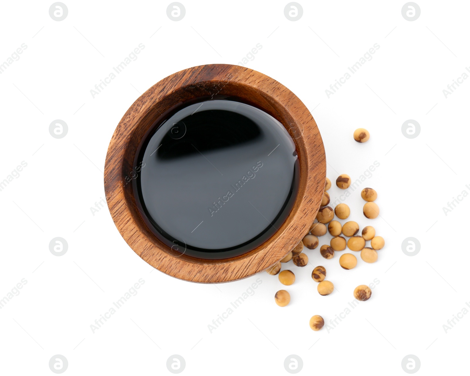 Photo of Tasty soy sauce in bowl and soybeans isolated on white, top view