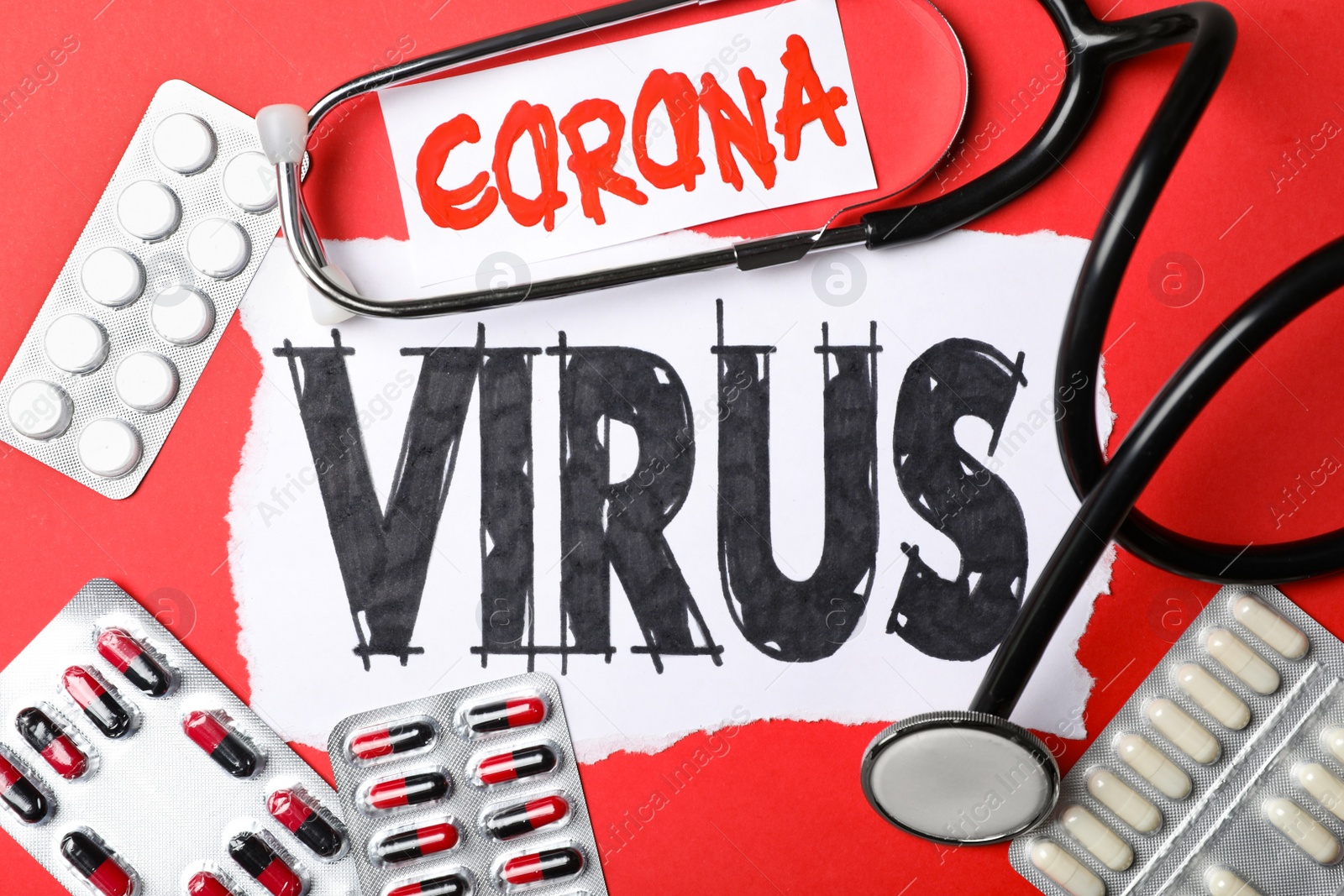 Photo of Flat lay composition with phrase CORONA VIRUS and medicines on red background