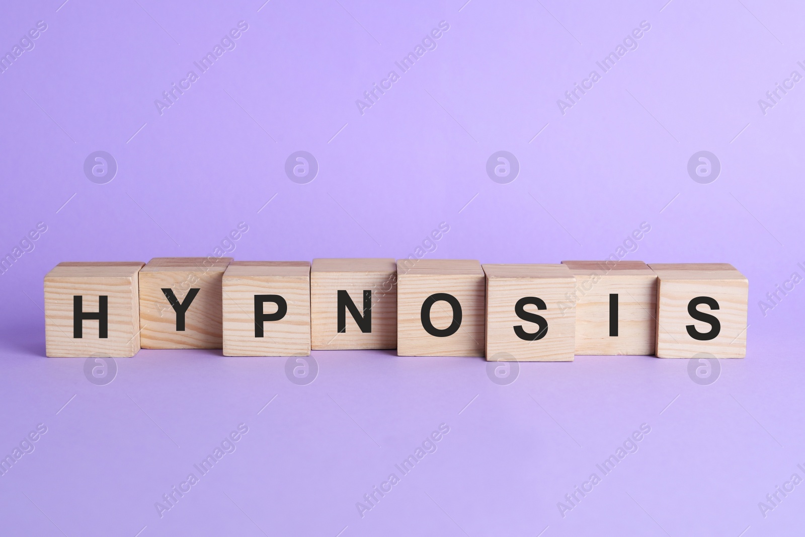 Photo of Wooden blocks with word HYPNOSIS on violet background