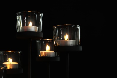 Photo of Burning candles on dark background. Funeral symbol