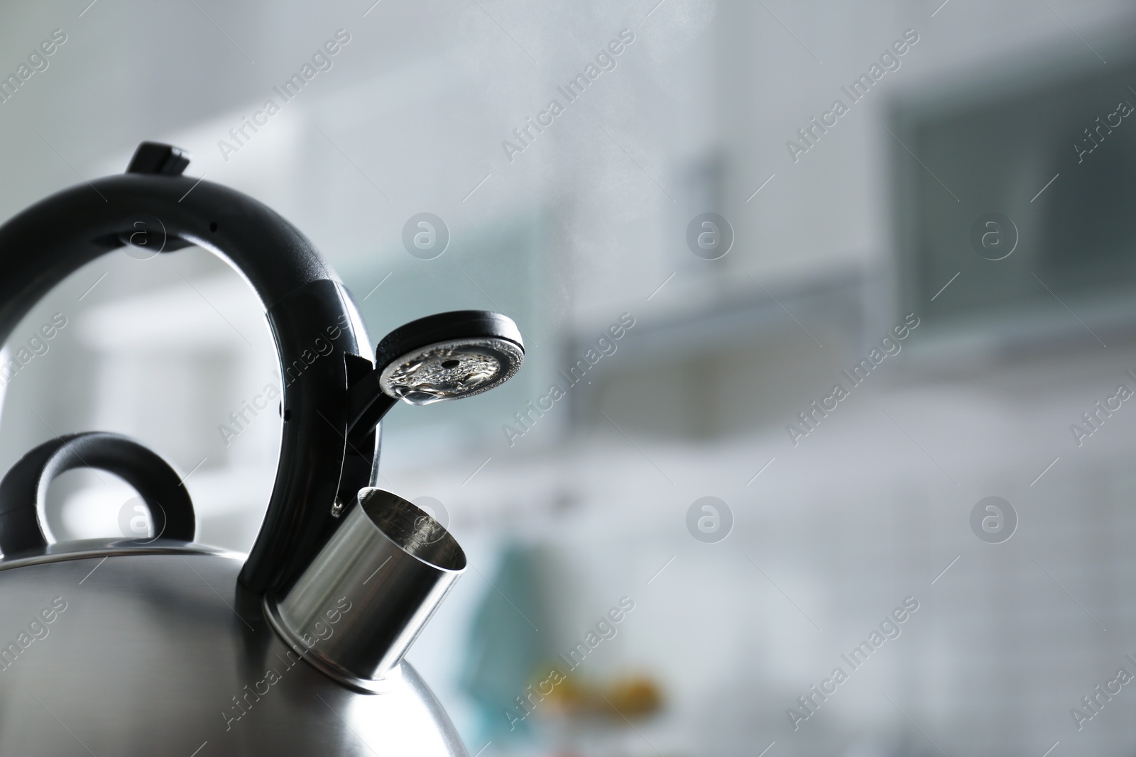 Photo of Modern kettle with whistle in kitchen, space for text