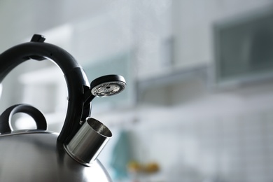 Modern kettle with whistle in kitchen, space for text