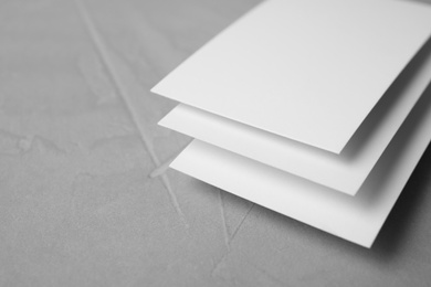 Photo of Blank business cards on light grey stone background, closeup. Mock up for design