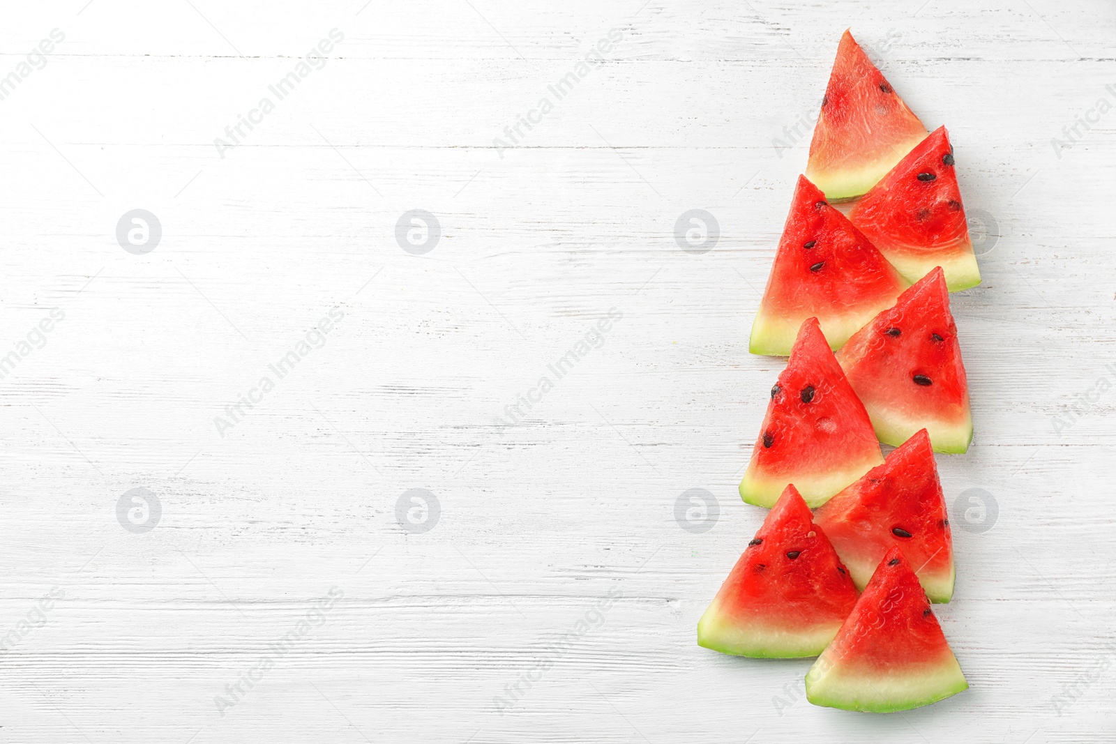 Photo of Slices of watermelon on wooden background, flat lay composition with space for text