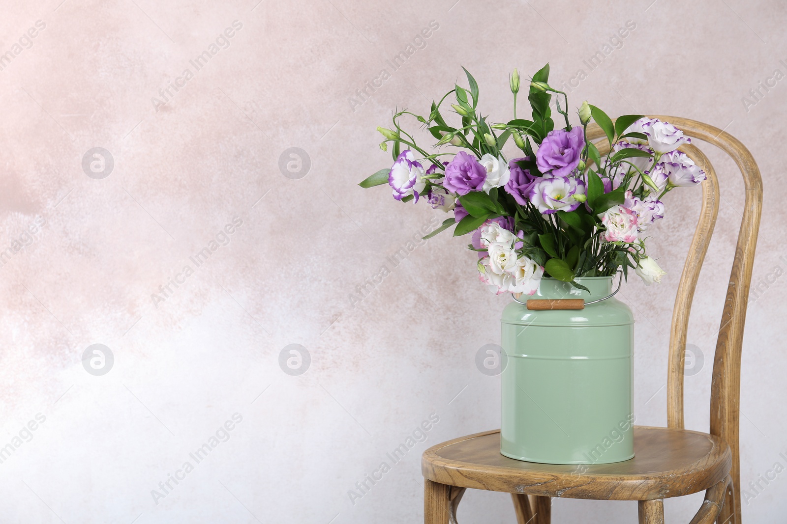 Photo of Vase with bouquet of beautiful flowers on chair against color background. Space for text