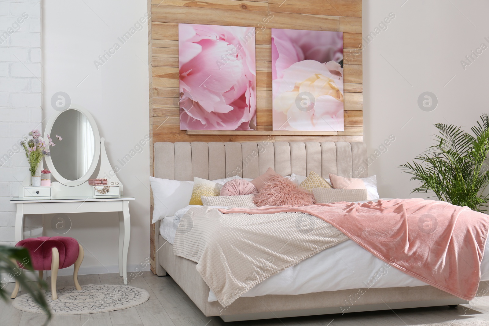 Photo of Stylish room interior with large comfortable bed and beautiful paintings