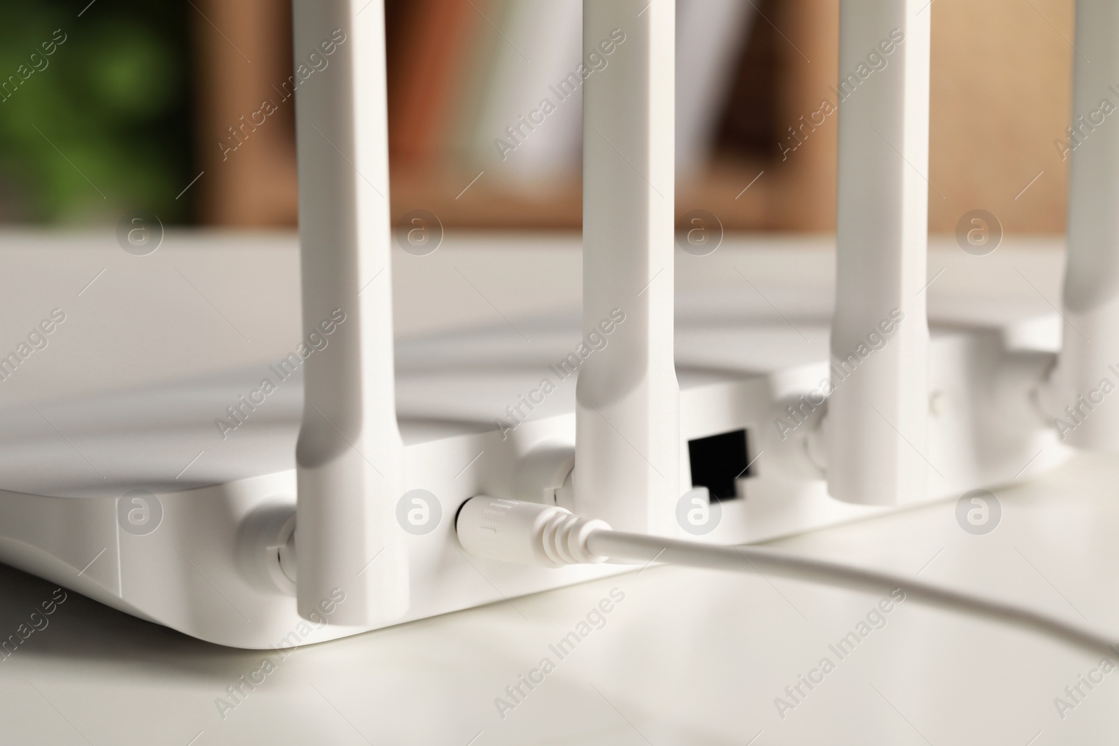 Photo of New Wi-Fi router on white table indoors, closeup