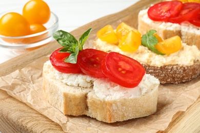 Tasty fresh tomato bruschettas on wooden board, closeup