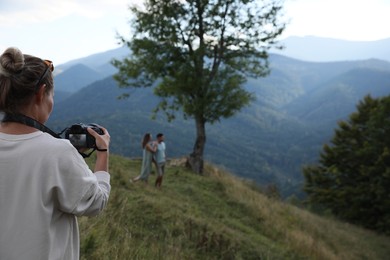 Professional photographer taking picture of couple in mountains