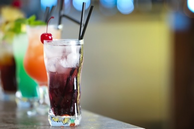 Photo of Row of different fresh alcoholic cocktails on bar counter