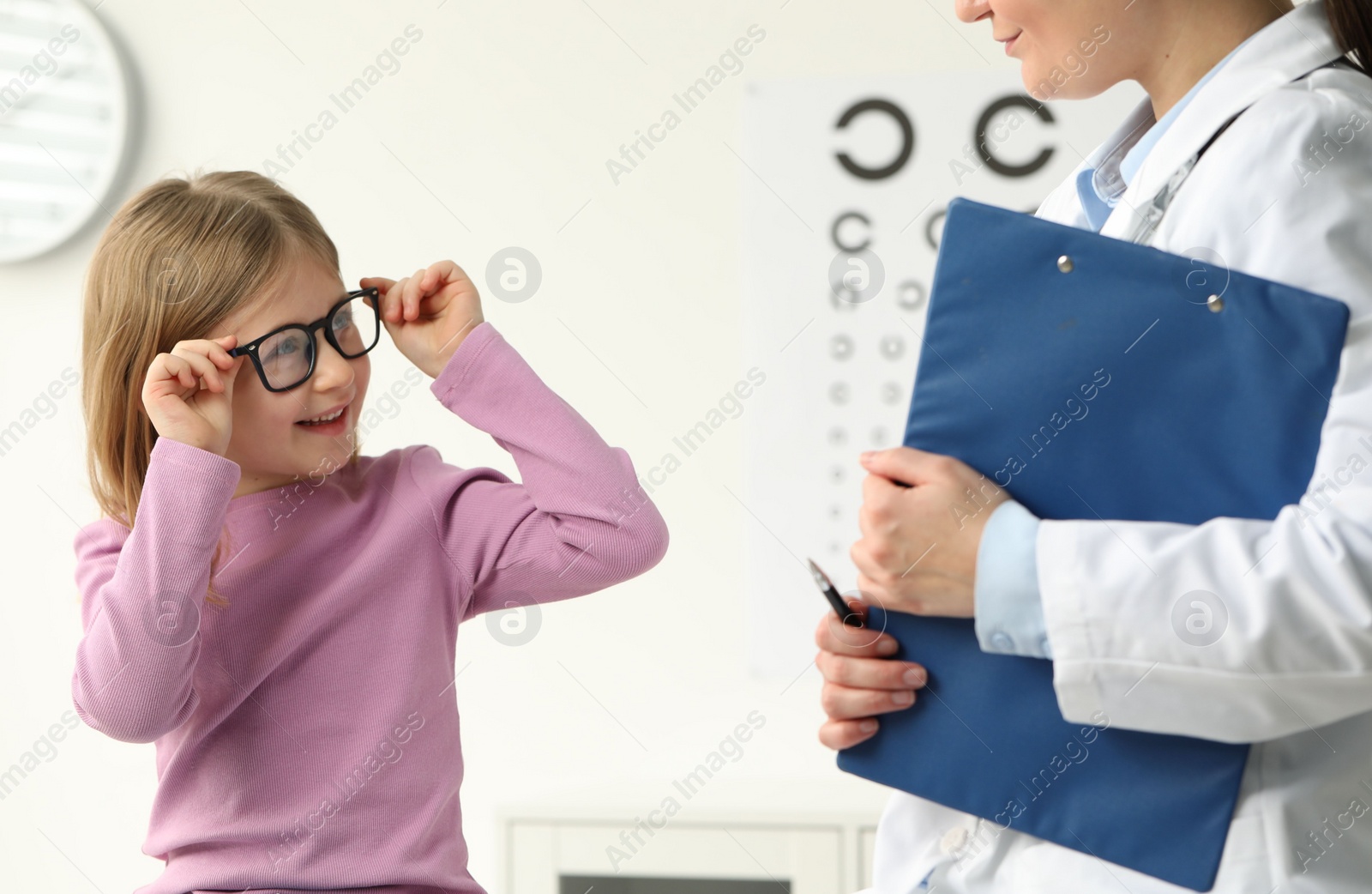 Photo of Vision testing. Little girl trying glasses at ophthalmologist office