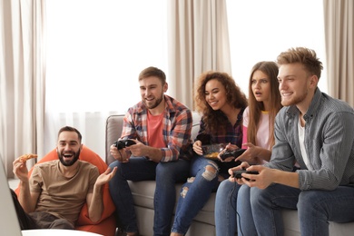 Emotional friends playing video games at home