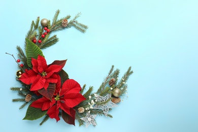 Photo of Flat lay composition with beautiful poinsettia on light cyan background, space for text. Christmas traditional flower