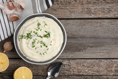 Photo of Tasty creamy dill sauce and ingredients on wooden table, flat lay. Space for text