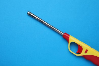 Photo of One gas lighter on blue background, top view. Space for text