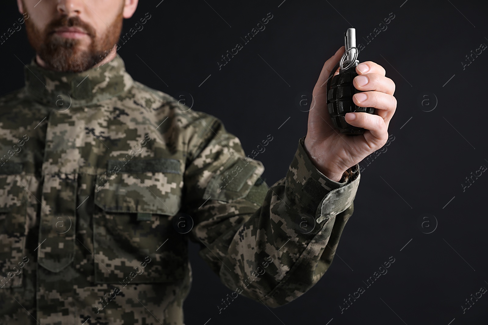 Photo of Soldier holding hand grenade on black background, closeup. Military service