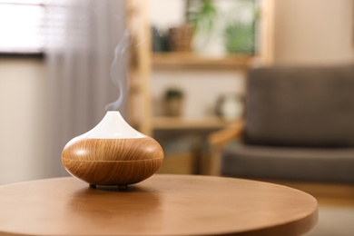 Aroma oil diffuser on wooden table at home, space for text. Air freshener