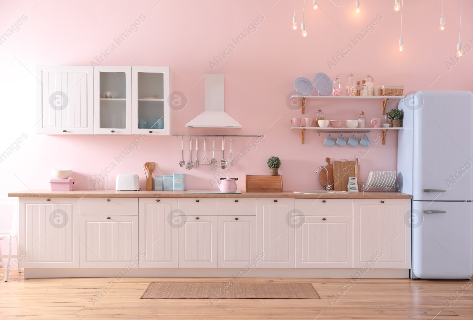 Photo of Stylish pink kitchen interior with modern furniture and fridge