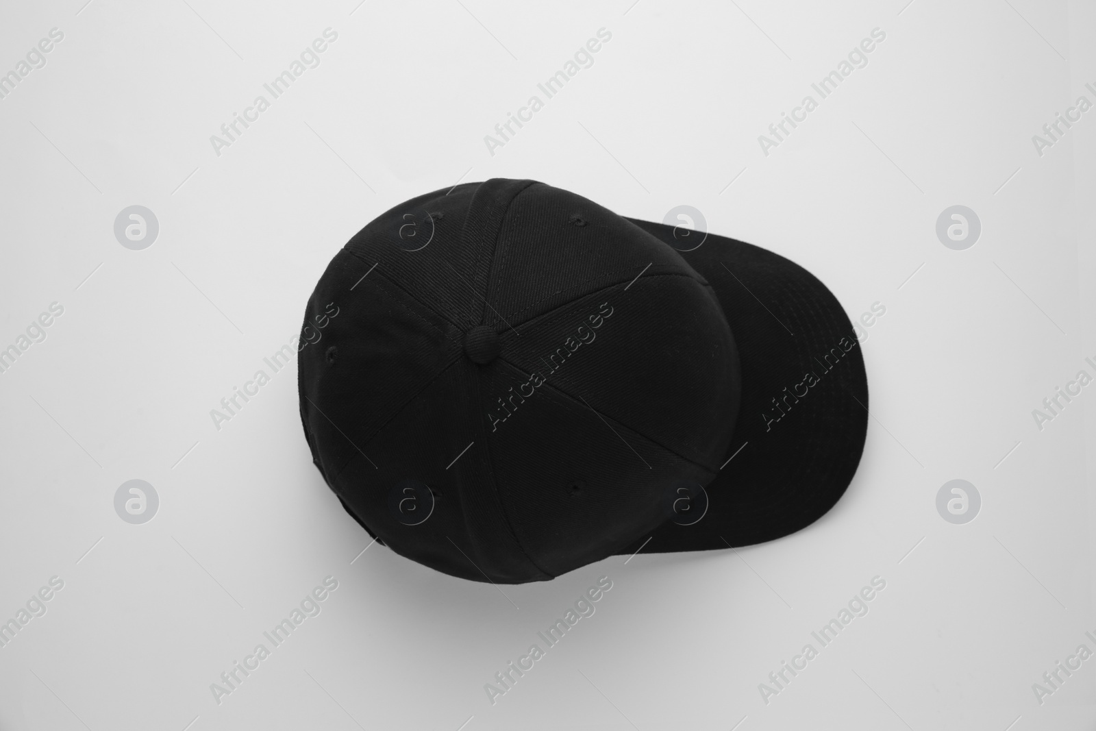 Photo of Stylish black baseball cap on white background, top view