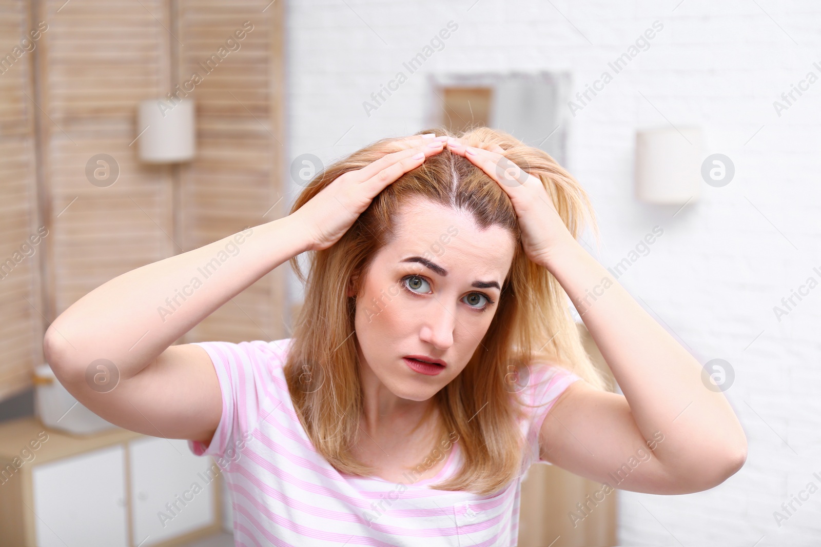 Photo of Emotional woman with hair loss problem in bathroom