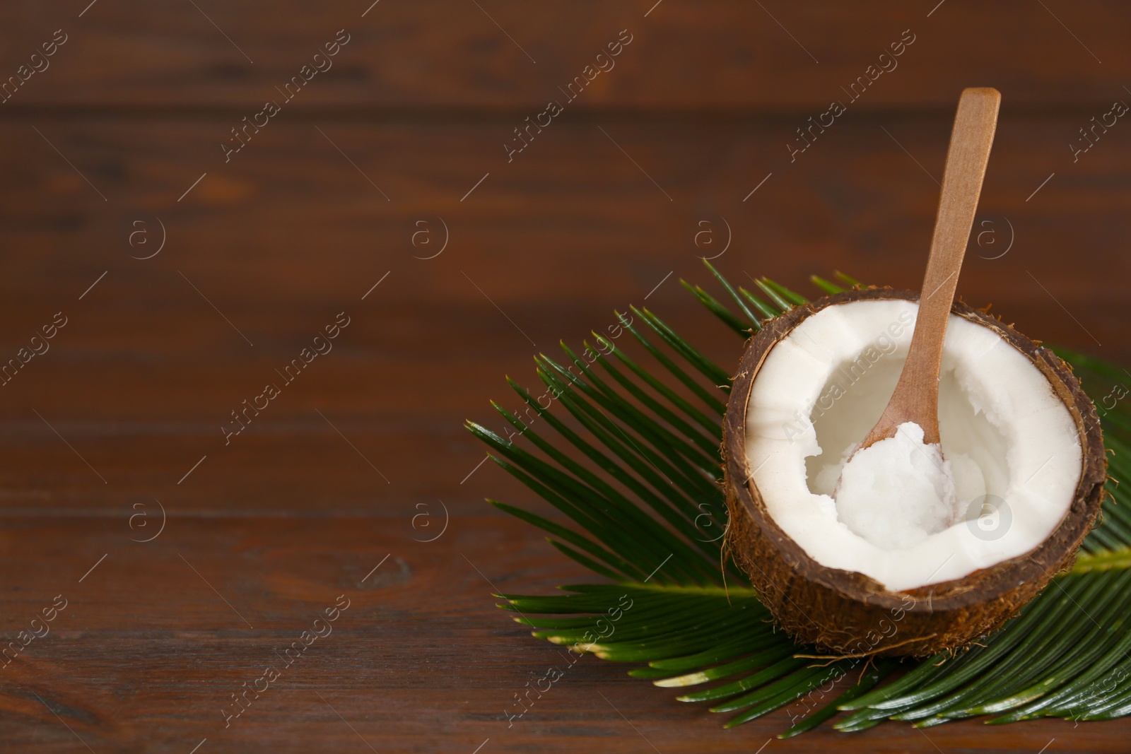 Photo of Composition with organic coconut oil on wooden table, space for text. Healthy cooking