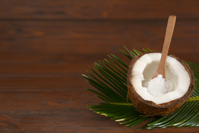 Photo of Composition with organic coconut oil on wooden table, space for text. Healthy cooking