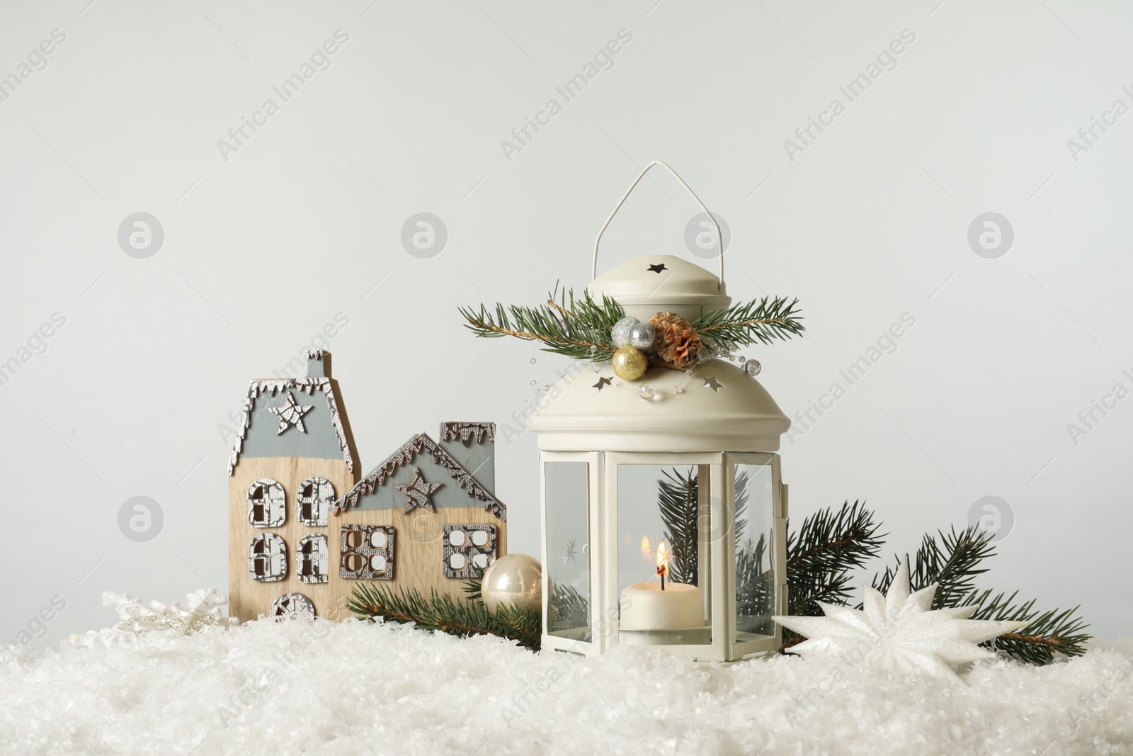 Photo of Beautiful composition with vintage Christmas lantern and festive decorations on snow against white background. Space for text