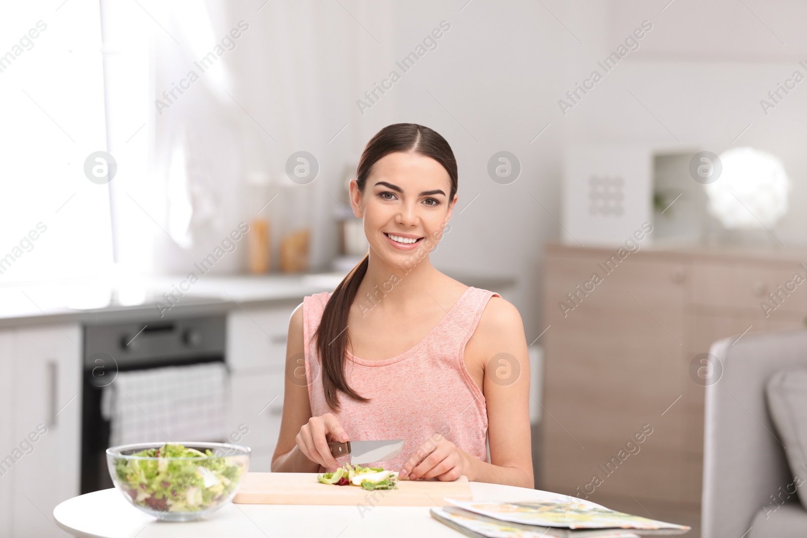 Photo of Young woman in fitness clothes preparing healthy breakfast at home