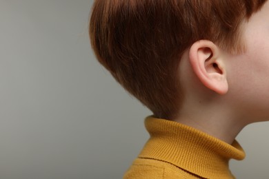 Hearing problem. Little boy on grey background. closeup. Space for text