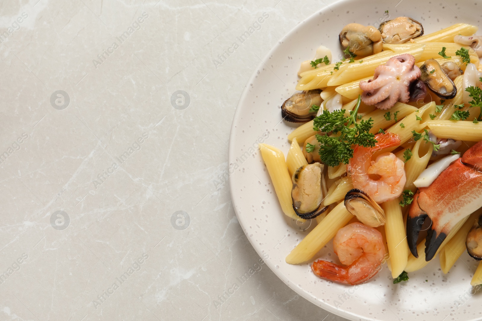 Photo of Delicious pasta with sea food on light grey table, top view. Space for text