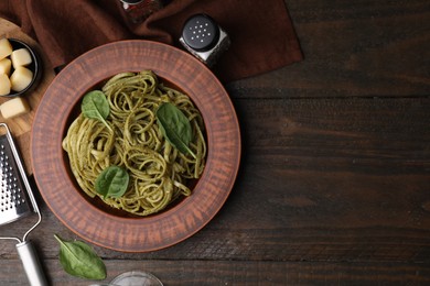 Photo of Tasty pasta with spinach served on wooden table, flat lay. Space for text