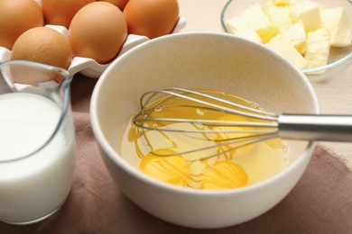 Photo of Whisking eggs in bowl on table, closeup
