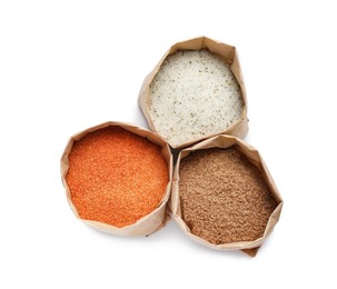 Photo of Different salts in paper bags on white background, top view