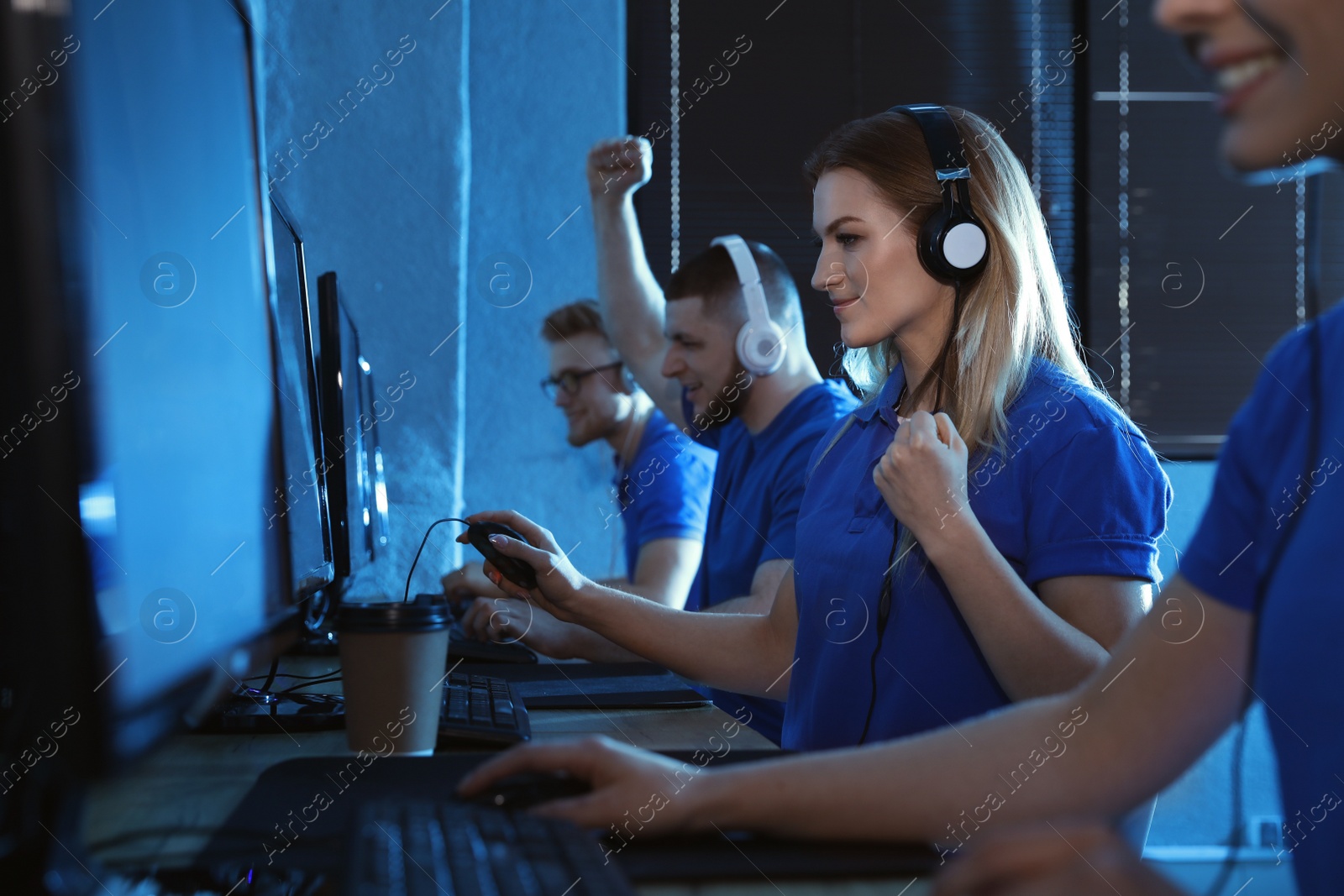 Photo of Group of people playing video games in internet cafe