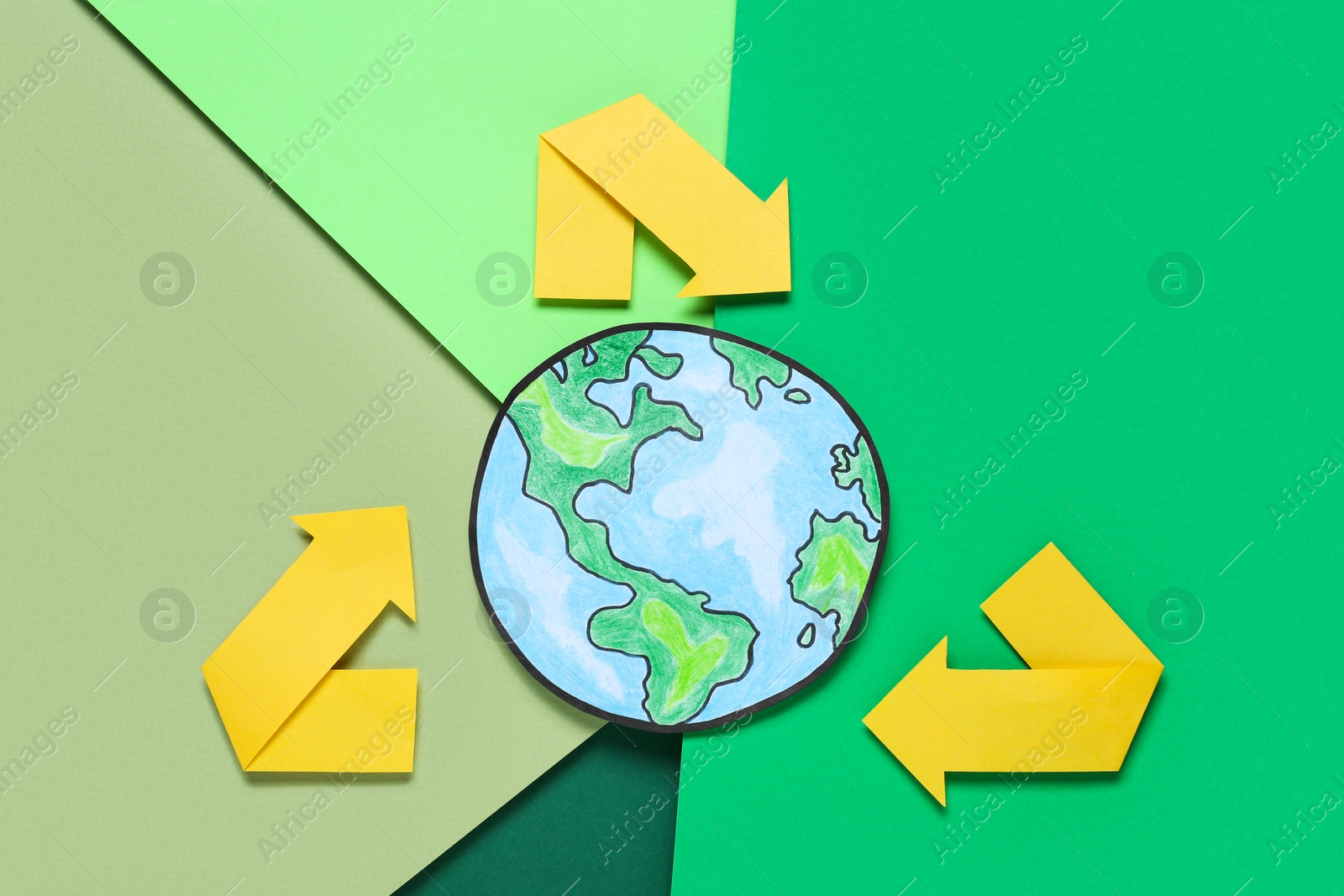 Photo of Recycling symbol and paper planet on color background, flat lay