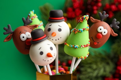 Photo of Delicious Christmas themed cake pops on blurred background, closeup