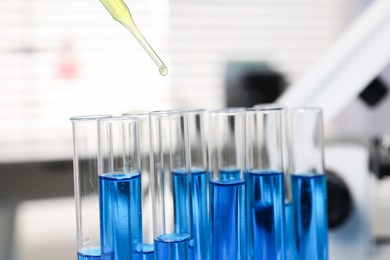 Photo of Laboratory analysis. Dripping liquid into test tubes indoors, closeup