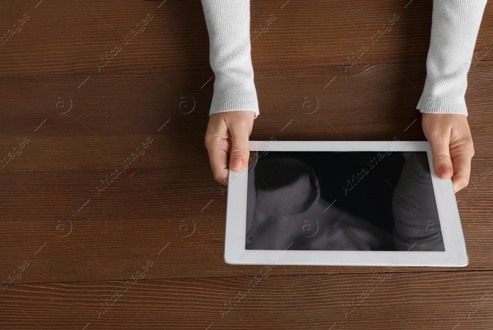 Photo of Woman working with tablet at wooden table, top view. Space for text