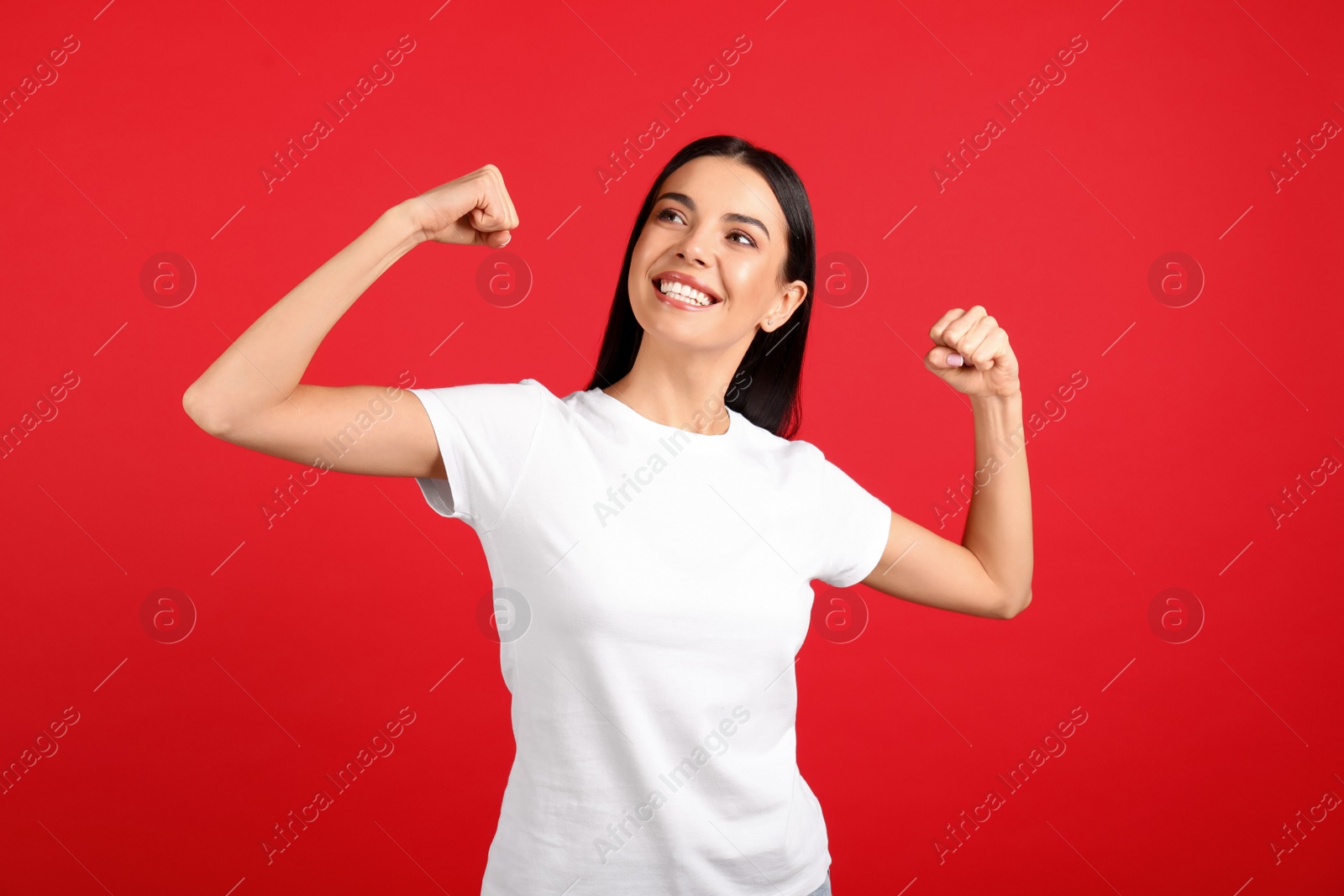 Photo of Strong woman as symbol of girl power on red background. 8 March concept