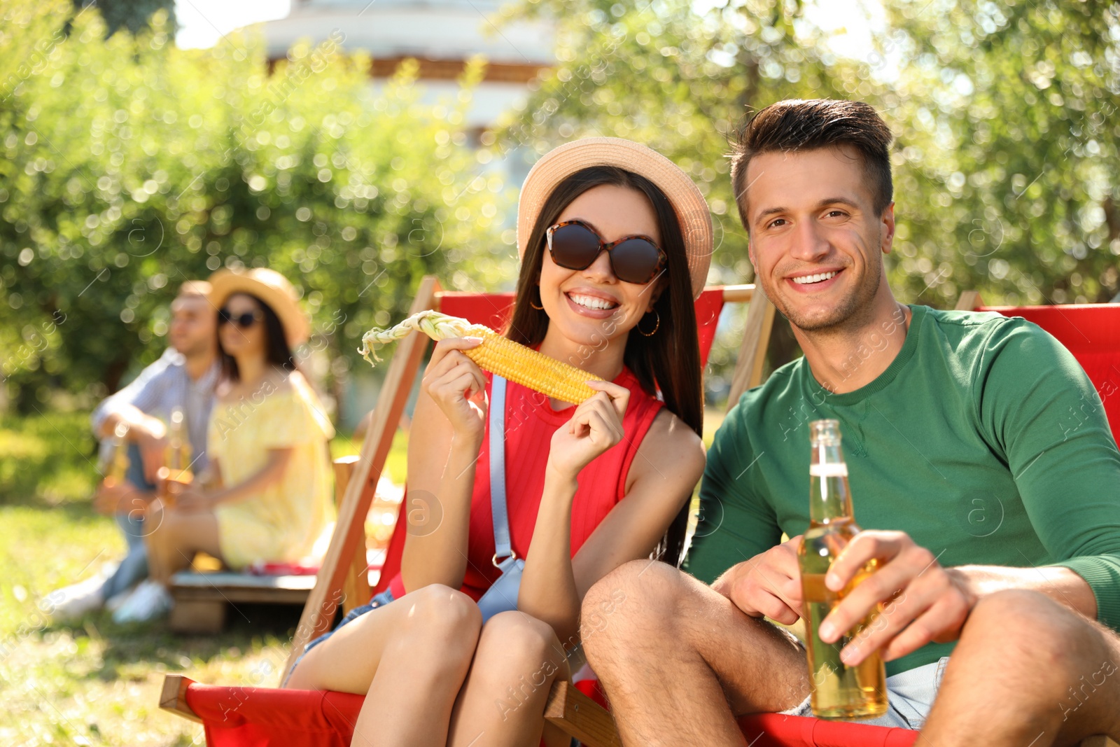 Photo of Young people enjoying picnic in park on summer day