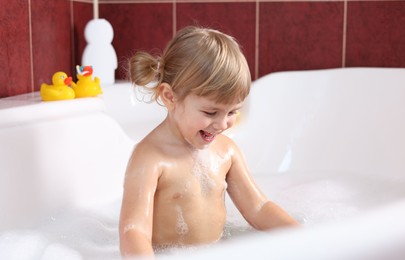 Photo of Happy girl bathing in tub at home