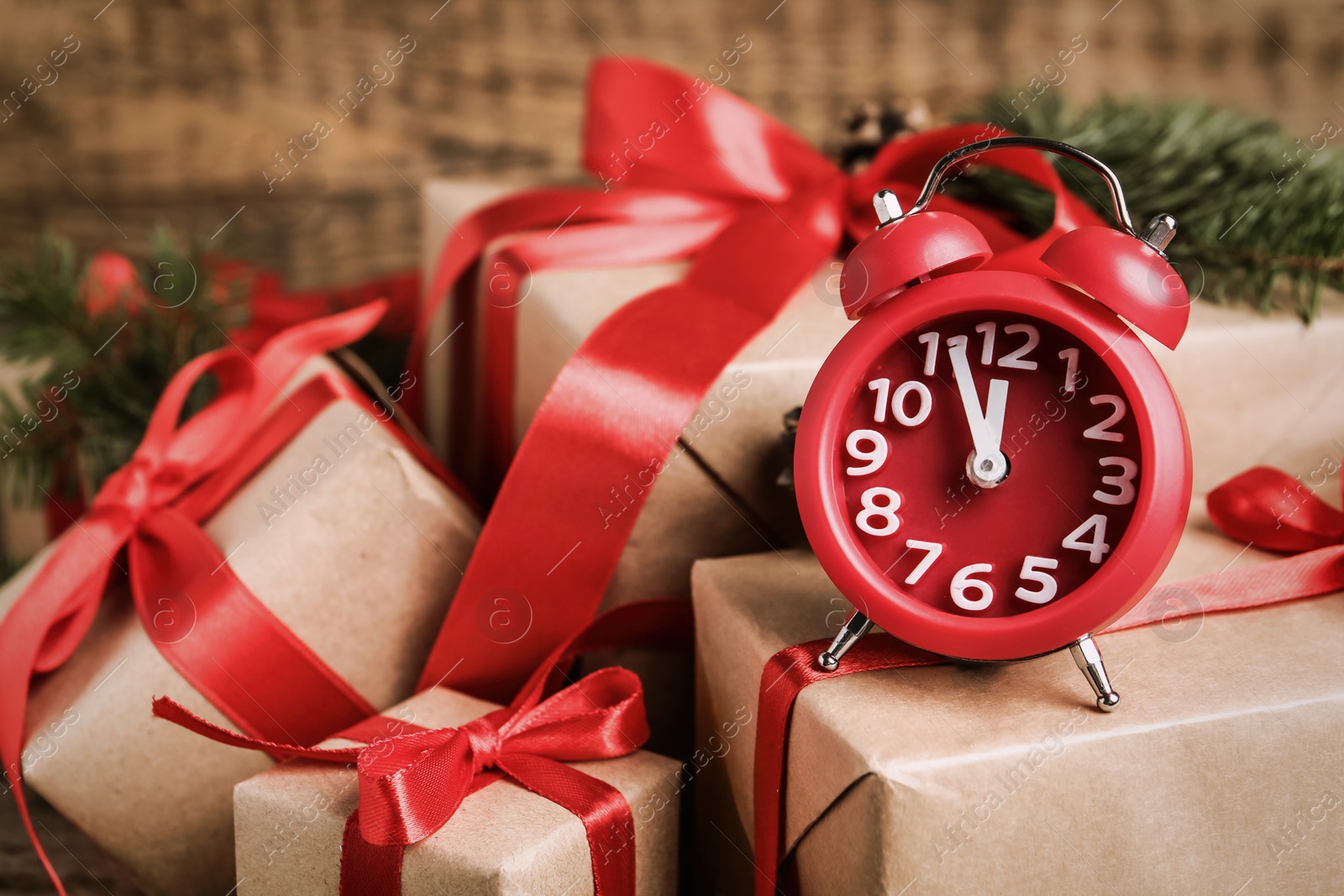 Photo of Alarm clock and Christmas gifts on wooden background, closeup. Boxing day