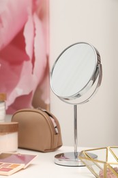 Photo of Dressing table with mirror, cosmetic products and jewelry in makeup room