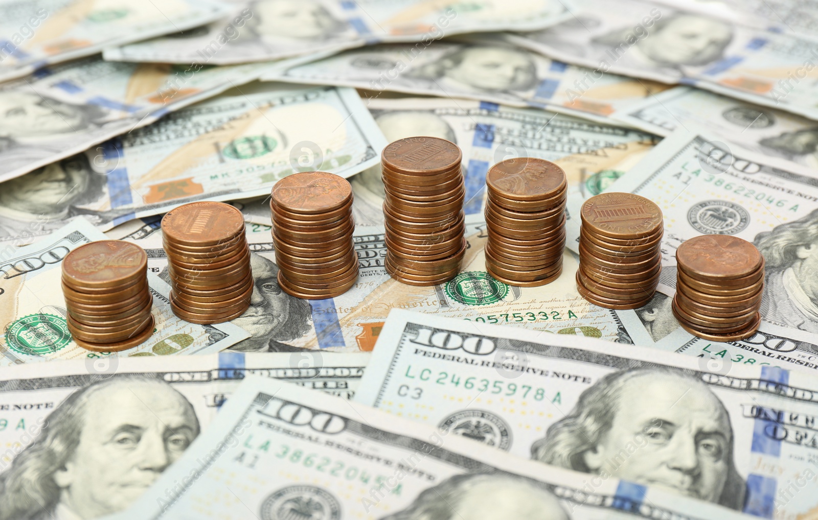 Photo of Stacks of metal coins on dollar banknotes