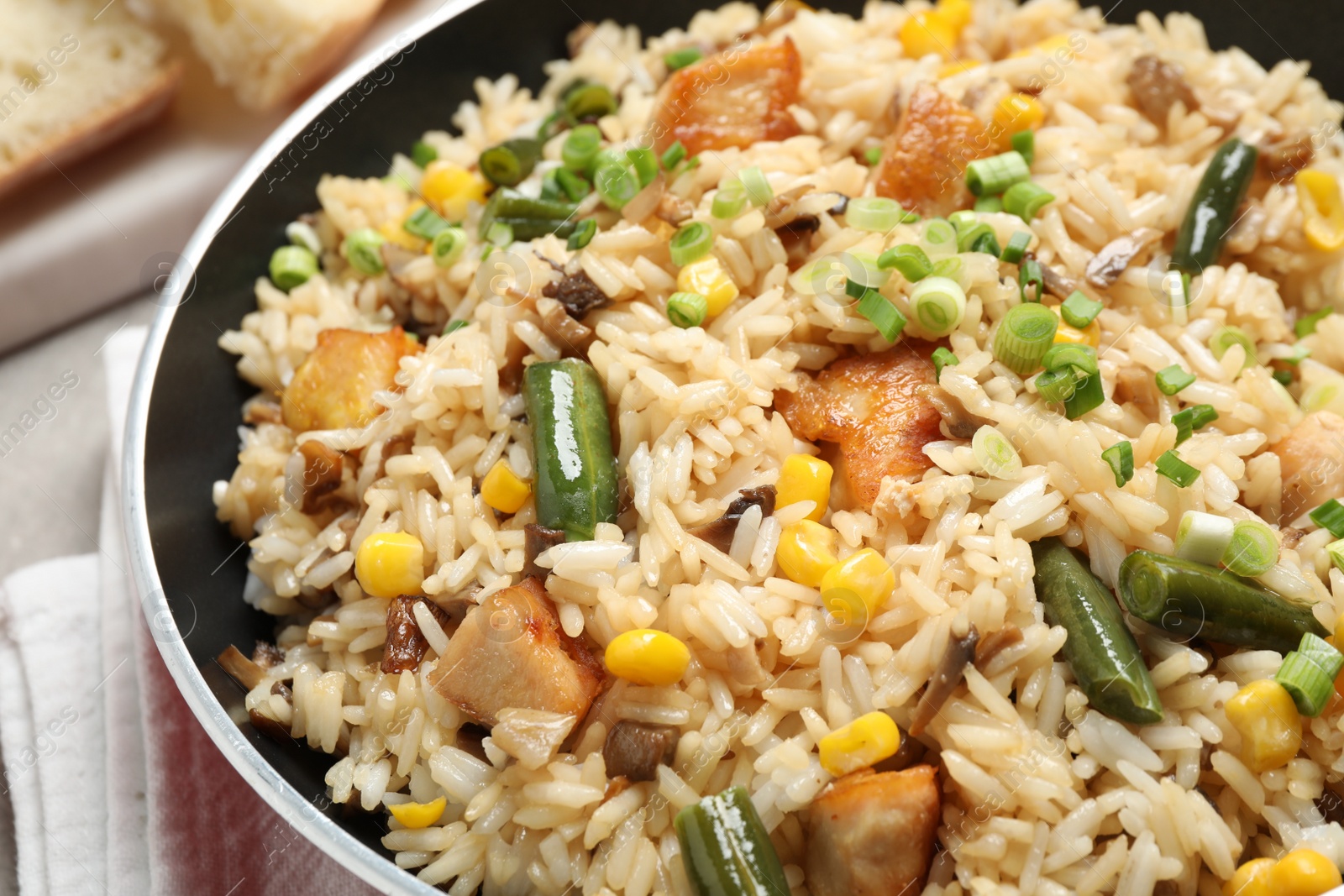 Photo of Delicious rice pilaf with chicken and vegetables in pan, closeup
