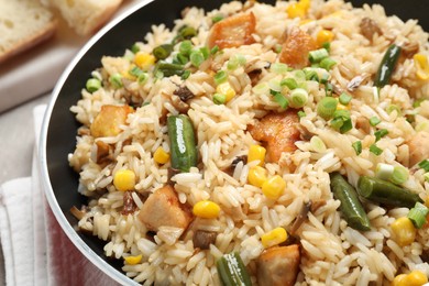 Delicious rice pilaf with chicken and vegetables in pan, closeup