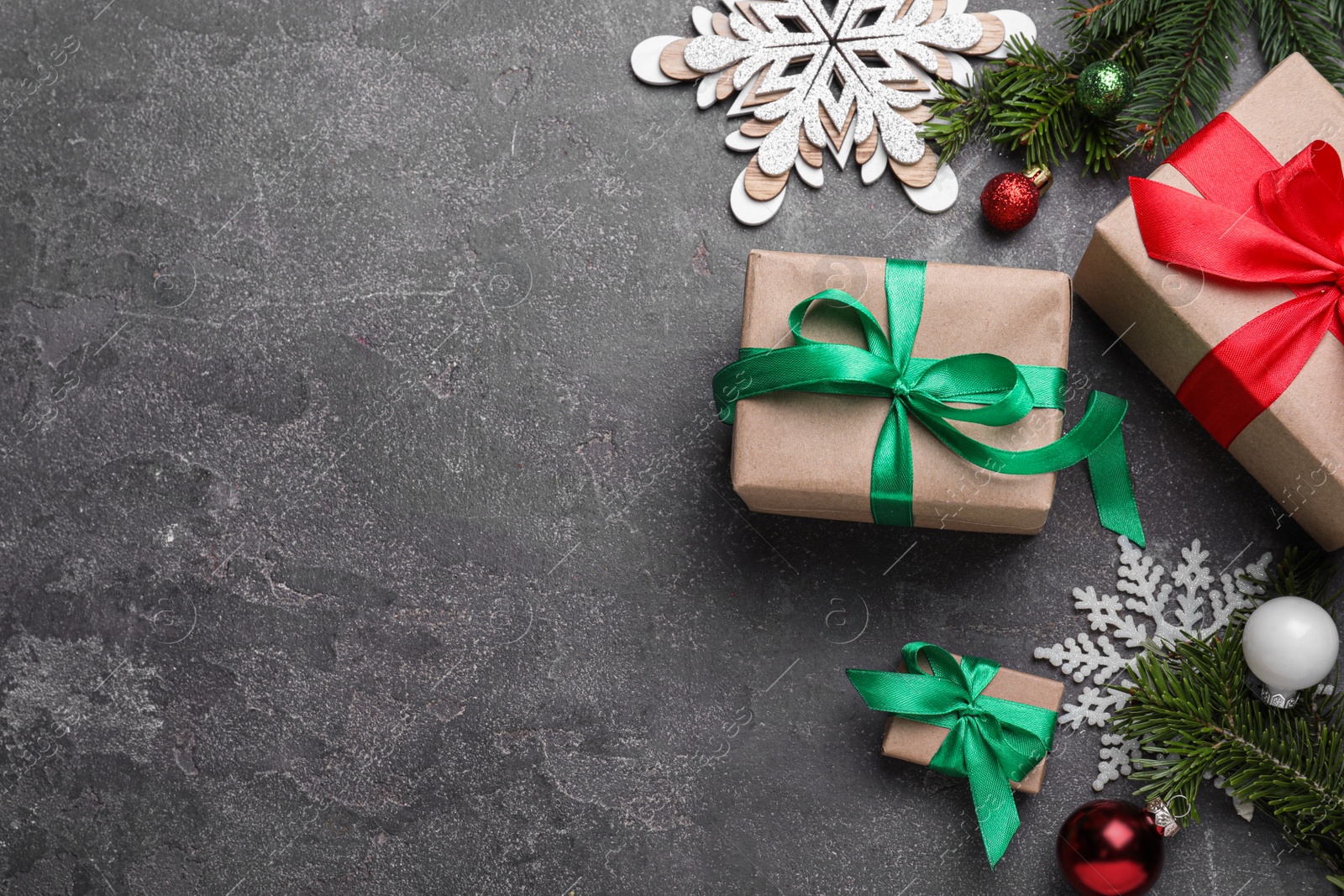 Photo of Flat lay composition with Christmas gift boxes on grey table. Space for text