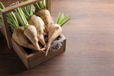 Basket with fresh sugar beets on wooden table, above view. Space for text