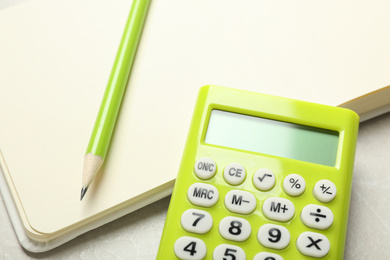Photo of Calculator, notebook and pencil on light table, closeup. Tax accounting
