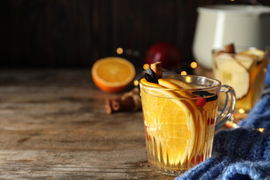 Photo of Aromatic mulled wine on wooden table. Space for text